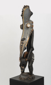 A totemic figural sculpture, carved wood, shell, fibre and earth pigments, Papua New Guinea, later wooden plinth, ​112cm high, 174cm high overall