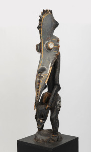 A totemic figural sculpture, carved wood, shell, fibre and earth pigments, Papua New Guinea, later wooden plinth, 112cm high, 174cm high overall