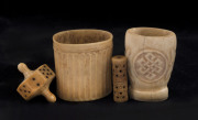 A sailor's whalebone gambling top, two carved rum cups and a toggle, 19th century, (4 items), the largest 5.5cm high