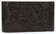 An Australian Arts & Crafts panel carved with kookaburra in gumnuts and gum leaves, circa 1900, most likely a panel from a fuel box (poor condition), 33 x 56cm