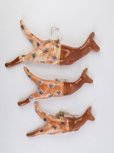 ARTIST UNKNOWN group of three pottery kangaroo wall plaques, the largest 39cm wide