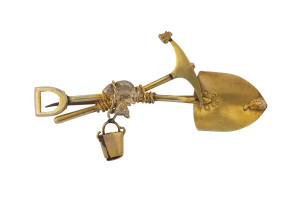 An Australian gold miner's brooch, crossed pick and shovel with hanging bucket, nugget specimen and entwined rope, 19th century, 5.5cm wide, 4.2 grams