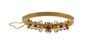 WENDT 9ct yellow gold bangle set with red stones and seed pearls, housed in original plush box marked "J.M. WENDT, ADELAIDE", clasp stamped "9" with circular crown mark, 6.5cm wide, 12.2 grams total