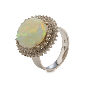 An 18ct white gold ring set with an impressive solid Coober Pedy white opal surrounded by two rows of white diamonds, stamped "750, 18ct",