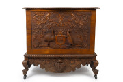 An impressive "ADVANCE AUSTRALIA" oak glory box, profusely carved with kookaburras, snakes, kangaroo and emu flanking a monogrammed crest "J.M.", the interior handsomely adorned with carved bird and swag emblazoned "With Best Wishes", circa 1880 ​95cm hig - 2