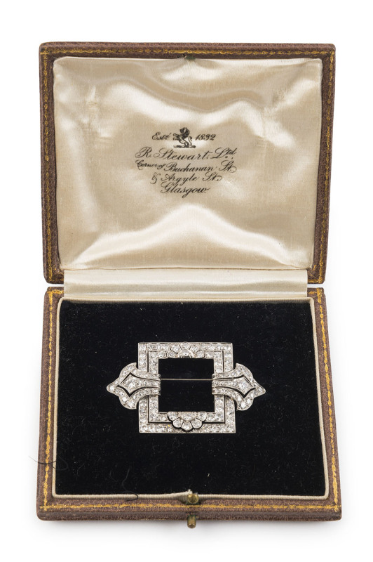 A stunning Art Deco brooch, 18ct white gold set with 104 diamonds (approximately 6.12ct), in original plush fitted box, retailed by R. STEWART of Glasgow. Formerly the property of DAME MARY COOK. 5cm wide, 11.8 grams. PROVENANCE: The Cook family, by desc