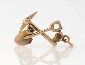 A goldfields pendant, crossed pick and shovel with nugget specimens, 19th century, 3cm high, 1.4 grams