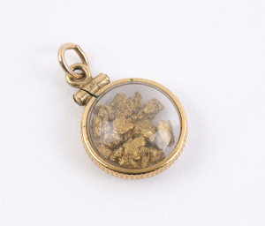A goldfields pendant with gold flake specimens encased in glass with yellow gold mounts, 2cm high