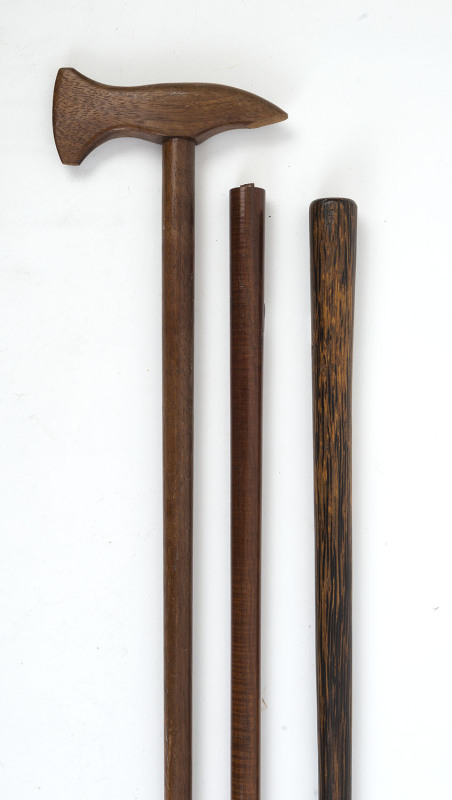An Australian blackwood axe shaped walking stick, and two other sticks with fiddleback blackwood shaft and a palmwood shaft, early 20th century, (3 items), the axe shaped stick 90cm high