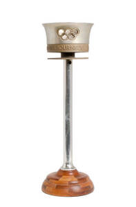 1956 Olympic Torch, aluminium, with legend around top "XVI OLYMPIAD 1956: OLYMPIA - MELBOURNE", mounted on wooden stand, overall 46cm tall.