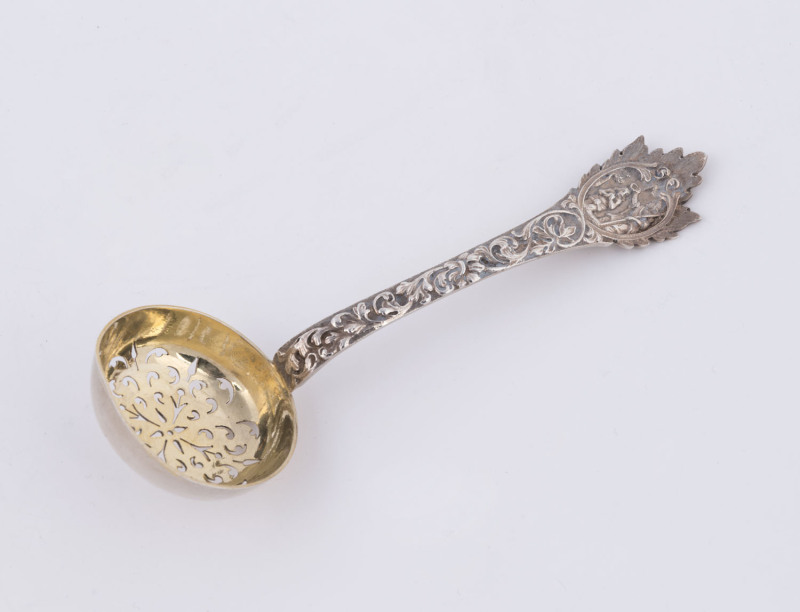 A sterling silver compote ladle, by Henry William Curry, London, 1878, in the Aesthetic style, depicting flowers and scrolls in relief with an anointing scene to the handle. 66gms.