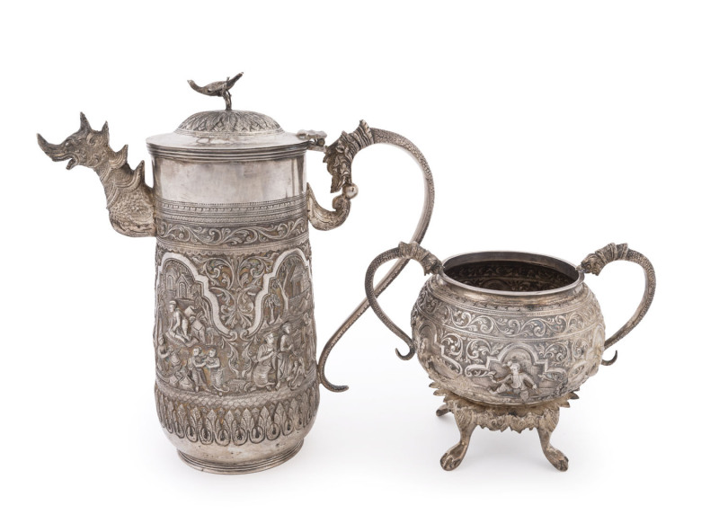A stunning Burmese silver teapot and sugar bowl adorned with dragon handle and spout, bird finial and fine repoussé work, engraved on the base "Coombe's Company Ltd. Silversmiths. Rangoon", 20cm high, 930 grams