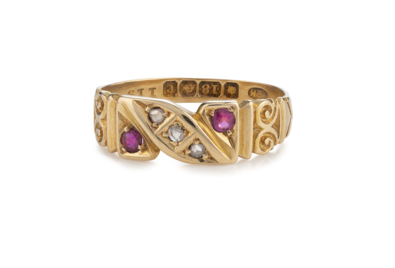 An English antique 18ct yellow gold ring set with three diamonds flanked by a pair of rubies, Birmingham, circa 1902, in a period leather ring case, 2.6 grams