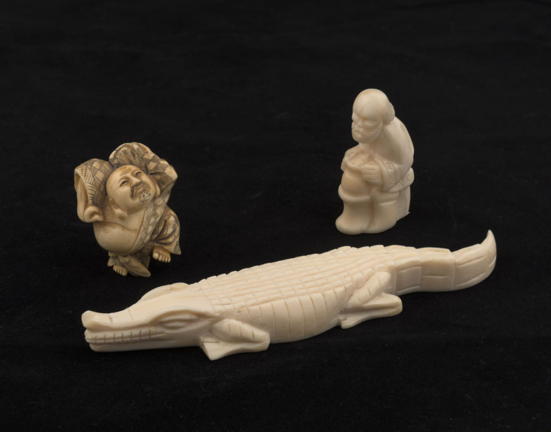 A Japanese carved ivory netsuke (Meiji period), together with two carved hippo tooth ornaments, ​the crocodile 14cm long