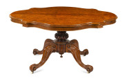 An antique English burr walnut supper table with shaped top and carved base, circa 1875, 75cm high, 154cm wide, 111cm deep