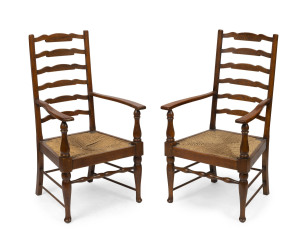 A pair of antique provincial English oak ladderback carver chairs with rush seats, 19th century, 107cm high, 58cm across the arms