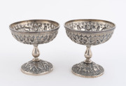 A pair of Persian silver bowls, each raised on a single central foot with highly ornamented designs, 7cm high, 7.5cm diameter, 160 grams total