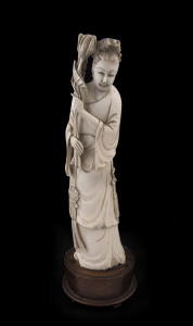An antique Chinese ivory figure of a woman with lotus on turned wooden base, late 19th century, 25cm high
