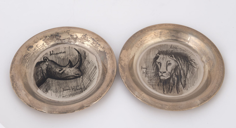 A pair of sterling silver plates engraved with images of a rhinoceros and a lion by Bernard Buffet, dated 1976 and 1977, 20cm diameter, 400 grams.