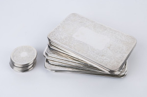 Ten silver plated place mats along with eight matching coasters, all with pressed floral decoration, 20th century. (18 items), the place mats 25.5cm wide, coasters 8cm diameter.