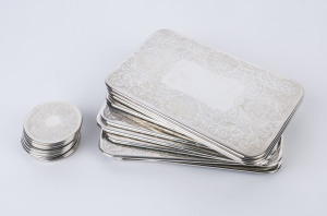 Ten silver plated place mats along with eight matching coasters, all with pressed floral decoration, 20th century. (18 items), ​the place mats 25.5cm wide, coasters 8cm diameter.