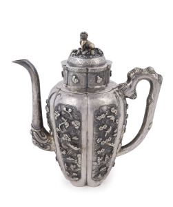 An antique Chinese silver teapot adorned with vignettes of country scenes and floral sprays, Foo dog finial with remains of gilt highlights, 19th century, 18cm high, 17cm wide, 565grams