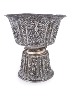 A Laotian silver footed bowl with repousse decorated and alternating panels of the three-headed elephant (airavata) and deities, separated by elaborate floral scrolling and borders with foliate lotus leaf pattern, early 20th century. A silver plaque attac