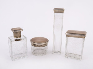 A set of four vanity bottles, wheel cut crystal with sterling silver and enamel lids, interiors with original gilt finish, made in London, circa 1911, ​the largest 17cm high