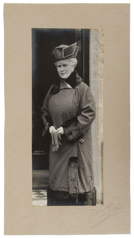 QUEEN MARY - QUEEN TO KING GEORGE V: signed photograph portrait in three-quarter length winter coat and hat, gloves in hand, signed on image "Mary R. 1925", mounted on card. 15 x 28cm overall