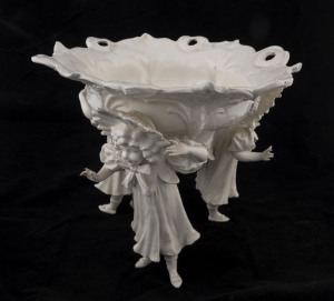 A Continental white porcelain table centrepiece, floral decorated bowl supported by three young female figures, early 20th century, factory mark to the base, 25cm high