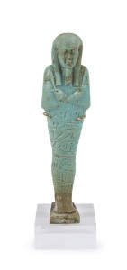 An Egyptian green faience shabti figure, circa 1st - 2nd Century AD, 15cm high