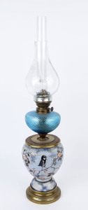 A porcelain based oil lamp with later blue glass font insert, shade and chimney, single burner marked "Paris", 72cm overall