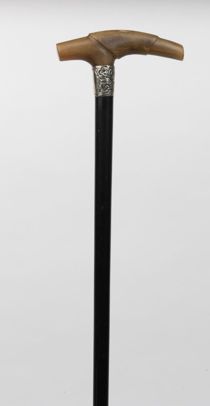 An antique walking stick, carved horn handle with sterling silver collar and ebony shaft, 19th century, ​88cm high