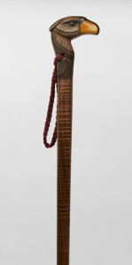 A walking stick with carved wooden bird's head handle and resin beak, fiddleback shaft with brass ferrule, early 20th century, 90cm high