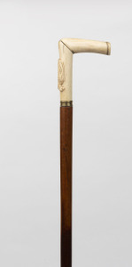 An antique walking stick, carved whalebone handle and ferrule with timber shaft, 19th century, ​87cm high