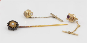 An antique gold and silver stickpin set with a seed pearl, together with two yellow gold tie pins, one set with a ruby, the other a diamond, (3 items), ​the stickpin 7cm long