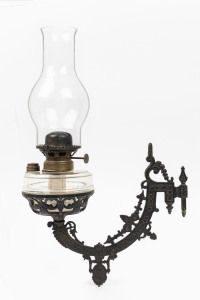 An antique wall sconce oil lamp with single Sherwood burner and glass chimney, ​50cm high overall