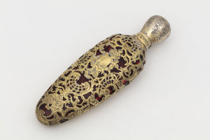 An antique French scent bottle, ruby glass with pierced silver overlay finished in gilt, circa 1870, 11.5cm high