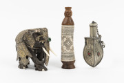 An ornate Indian elephant statue, an Eastern powder flask, and a Dayak container, (3 items), the largest 16cm high