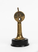 A vintage brass novelty desk cigar cutter in the form of a ships engine order telegraph (E.O.T) on ebonised timber base, the control handle operating the steel cigar cutting mechanism, circa 1930, 15cm high