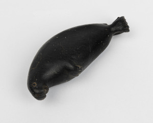 A Canadian Inuit greenstone carving in the form of a walrus, signed and numbered to the base, 20th century, 12cm long
