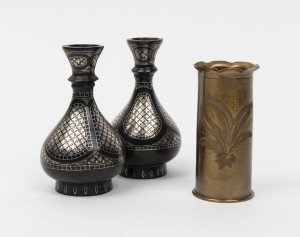 A Trench Art brass shell vase with scalloped top edge and engraved floral decoration, together with a pair of vintage Persian bidri ware niello decorated bud vases, 20th century, (3 items), the bud vases 11cm high