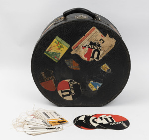 A vintage 1950's blue faux leather circular hat case, with applied travel stickers, along with an envelope of "Orient Line" luggage tags and stickers. The travel case 43cm high, 46cm wide, 19cm deep