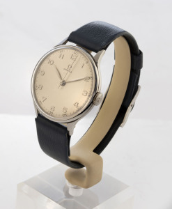 OMEGA manual wind gentleman's wristwatch with off white dial marked with Arabic numerals in a stainless steel case with blue leather strap, with "Omega" jewellers watch stand, circa 1955