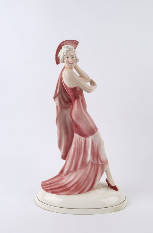 An Art Deco porcelain statue of a lady in pink dress with fan, circa 1930, ​46cm high