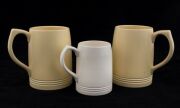 KEITH MURRAY: Three Wedgwood cream and yellow porcelain tankards. The two yellow examples with signature stamps "Keith Murray Wedgwood, Made In England", the other stamped "Wedgwood Of Etruria & Barlaston, Made In England, K.M.", the tallest 12cm high