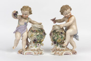 A pair of German figural vases with applied floral decoration, circa 1875, 23cm high