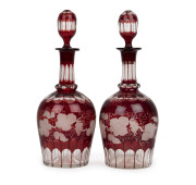 A pair of antique English ruby overlay glass decanters with engraved vine motif, 19th century, 32cm high