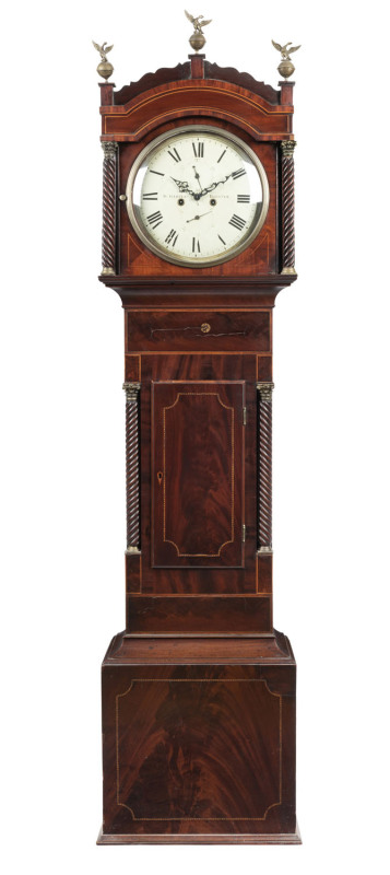 An antique English grandfather clock with 8 day weight driven movement, flame mahogany with marquetry inlay trunk, door flanked by four barley twist columns with Corinthian brass capitals and matching decoration to the hood. Scallop decorated crest with t
