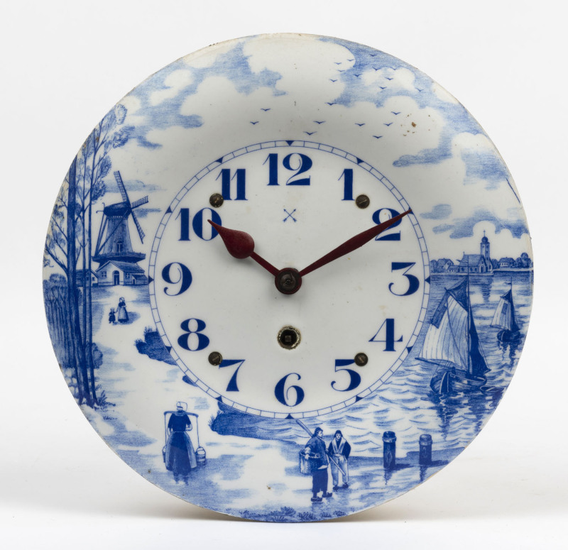A vintage blue and white enamel Delft style wall mount plate clock, early to mid 20th century, 27cm diameter